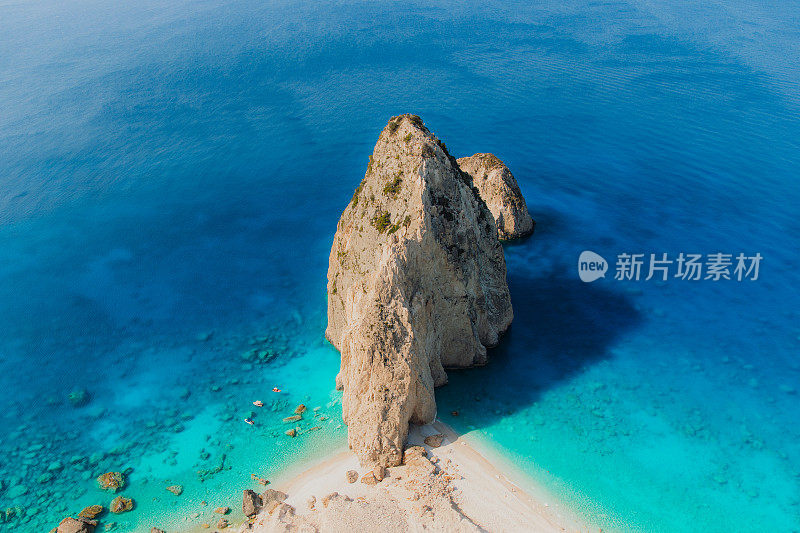 在扎金索斯岛(Zakynthos island)隐秘的海滩上，船只在水晶蓝色的大海上航行的风景如画